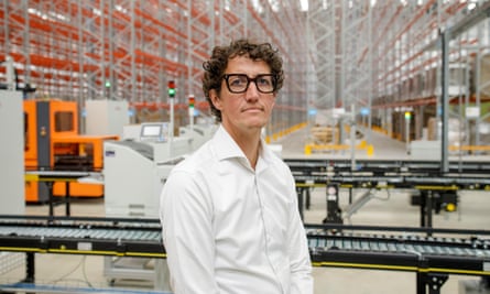 Jeroen Dekker, in shirt sleeves, poses for a photos in the warehouse