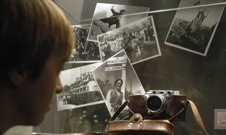 a visitor observes a Leica camera from Agusti Centelles and some of his pictures part of the exhibition Journey to a War. George Orwell in Catalonia and Aragon