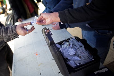 A person hands packaged drugs to another person over a table