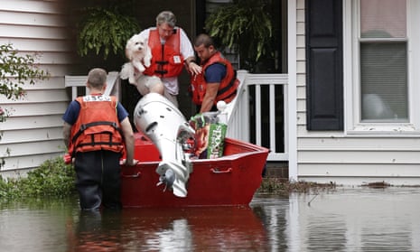Roger Hedgepeth is assisted along with his dog Bodie by members of the US Coast Guard in Lumberton, North Carolina