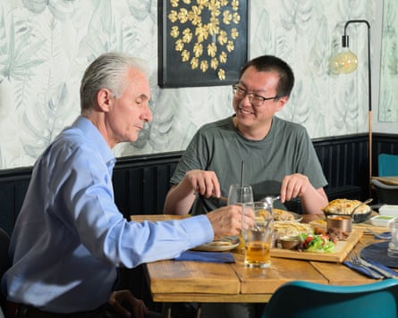 Phill picking up food as Joe smiles