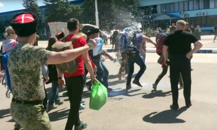 Film still showing Cossacks throwing milk at opposition leader Alexei Navally at Anapa airport.