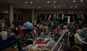 People of all ages sit or lie down inside a Kyiv metro station