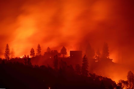 Flames from the Camp fire burn near a home atop a ridge near Big Bend, California.