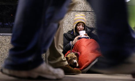 A homeless woman from north Wales, sits huddled under a sleeping bag next to her dog Casper in a shopping arcade near the Victoria rail station in central London.