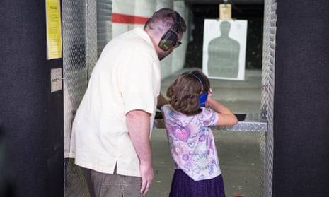 Pastor and NRA firearms instructor John offers guidance to his 8-year-old daughter Abby at the gun range
