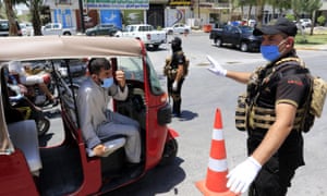 Iraqi policemen stand at a checkpoint during a curfew earlier this month as a part of restrictions against the spread of Covid-19 at the holy city of Karbala, south of Baghdad, Iraq.