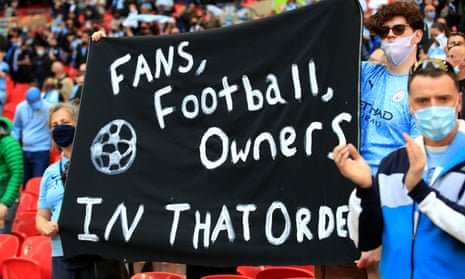 Supporters hold up a banner protesting against the European Super League proposals