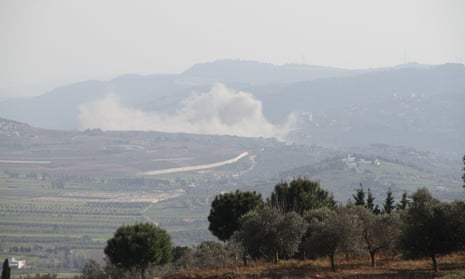 Smoke caused by an Israeli airstrike rises against the backdrop of mountains, behind green fields, in Baalbek, Lebanon