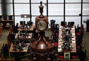 A man works at a desk in the Lloyd’s of London building in the City of London financial district.