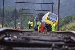 Rochefort, Belgium: Rail workers stand near a derailed carriage after heavy rains and floods hit the area.