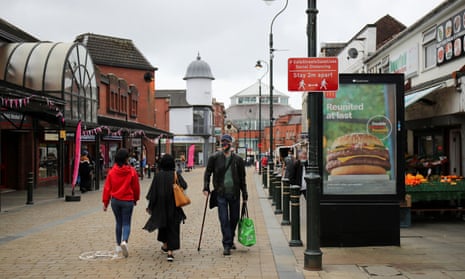 People walk past a social distancing sign in Oldham, Greater Manchester
