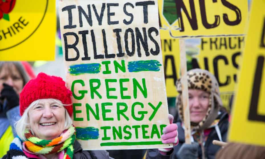 Demonstrator holds up a sign calling for more investment in green energy