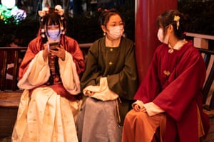 Women wearing traditional outfits chat during subdued lunar new year celebrations in Yokohama, Japan