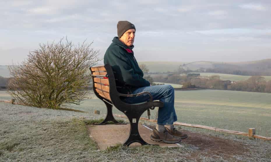 Walker David sentado en un banco en Clayton Hill, South Downs