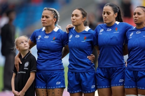 A young mascot looks up anxiously at the Samoa captain Sui Pauaraisa during the anthems before the Women’s Rugby World Cup 2025 Group A match between Australia and Samoa.