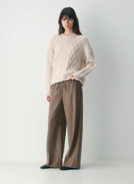 woman wearing cream sweater and taupe trousers