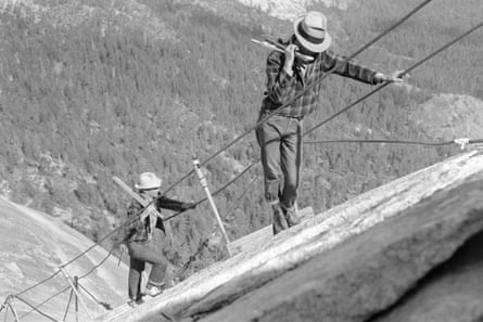 black and white picture of workers installing cables on a steep mountain slope