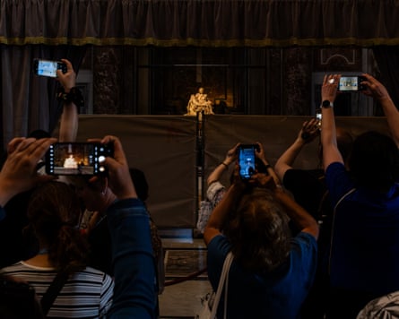 Visitors raise smartphones towards Michelangelo’s Pietà inside St Peter’s Basilica