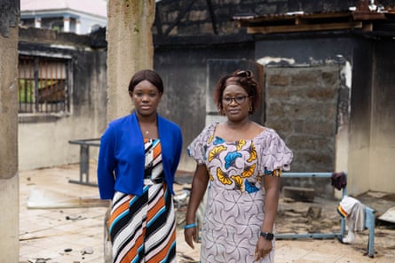 Two African women stand in the courtyard of a dilapidated building.