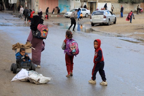 Women and children leave Rafah with their belongings in backpacks