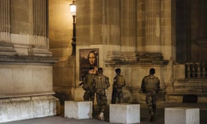 Military patrol near the Louvre museum during curfew in Paris Saturday night. The monthlong curfew came into effect Friday at midnight, and France is deploying 12,000 extra police to enforce it.