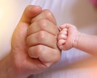 A father fist bumps a baby