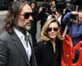 Russell Brand and his wife Laura arrive at court, photographers crowding behind them