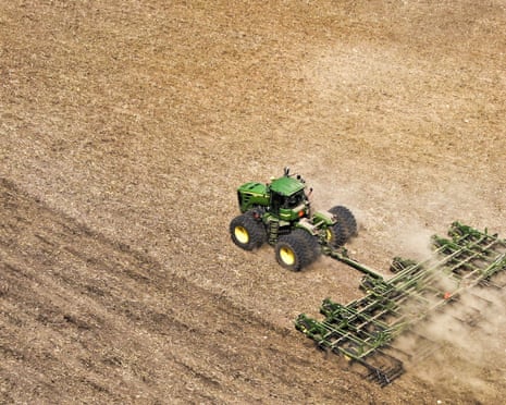 overhead view of a farmer on a tractor preparing a field for spring planting