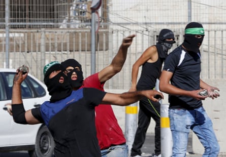 Palestinians throw stones towards Israeli border police during clashes at a checkpoint between Shuafat refugee camp and Jerusalem.