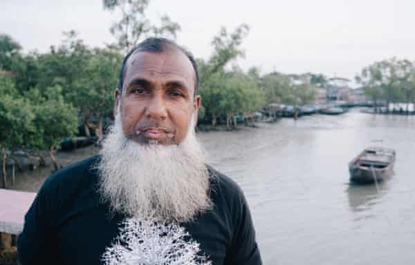 Very bearded man with river and mangroves behind him