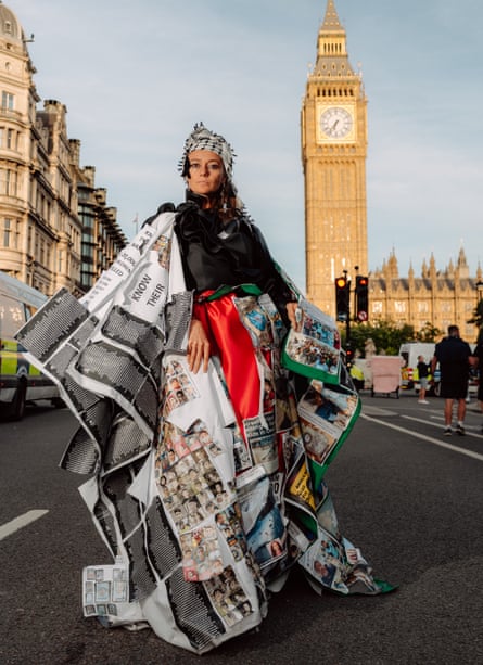 A woman in a voluminous gown printed with protest images
