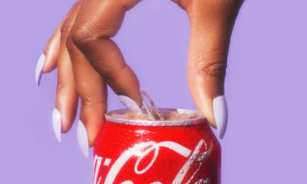 A hand with long fingernails painted pale purple, opening a can of Coca-Cola