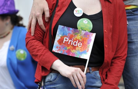 A woman holds a Pride flag