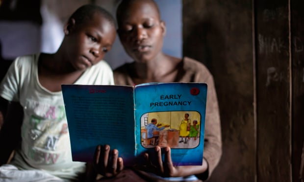 Adolescent Girls at Community Center in Uganda<br>Girls read an educational book at an adolescent youth center in Uganda. The girls are offered critical life skills training to help them manage socail issues. Low contraceptive usage has fuelled fertility with 59% of girls pregnant by the age of 20.