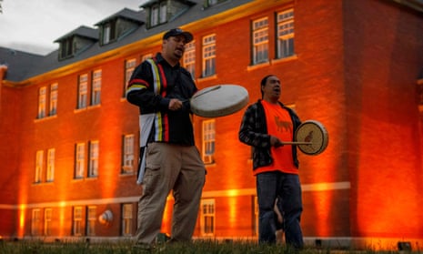 Thundersky Justin Young, left, and Daryl Laboucan drum and sing healing songs at a makeshift memorial to honor the 215 children whose remains have been discovered buried near the former Kamloops Indian Residential School in British Columbia, earlier this month.