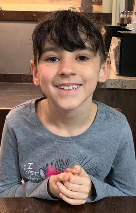 A young girl smiles.