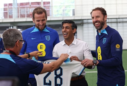 Rishi Sunak poses with an England shirt as he stands alongside Harry Kane and Gareth Southgate.