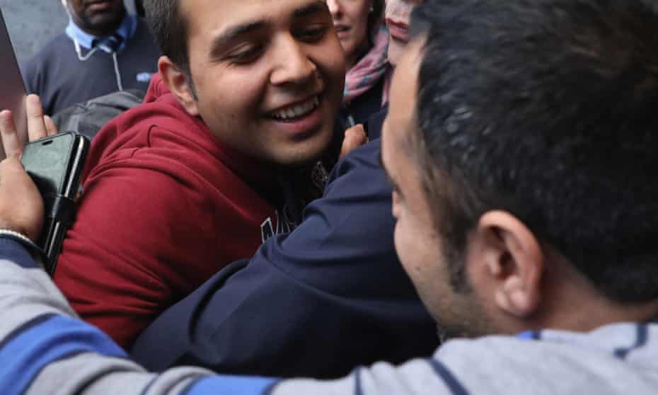 Jan Ghazi, (front right) greets his nephew Haris (centre) as he arrives in the UK from Calais