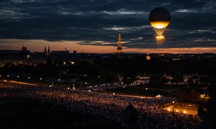 The crowd point their phones towards the balloon take off in the Tuileries Garden