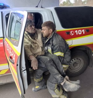 A rescuer carries the woman into an emergency vehicle