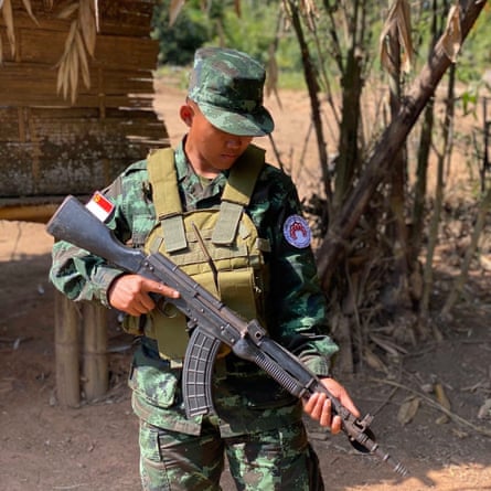A man in camouflage army uniform holding an AK-47-type assault rifle