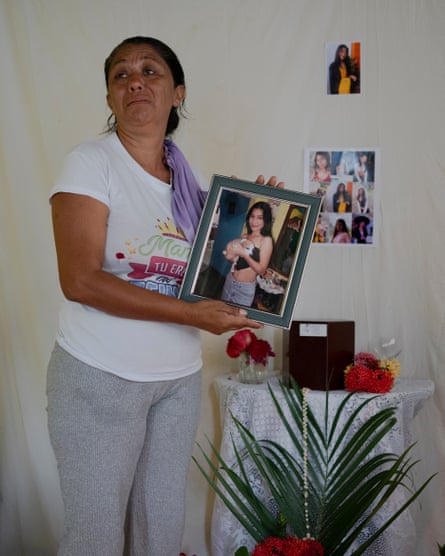 Yaritza García holds a photo of her late daughter, Alexandra, whose ashes lie in a wooden box behind her at her home in Poblado Uno, Portuguesa State, Venezuela, on 13 July 2026