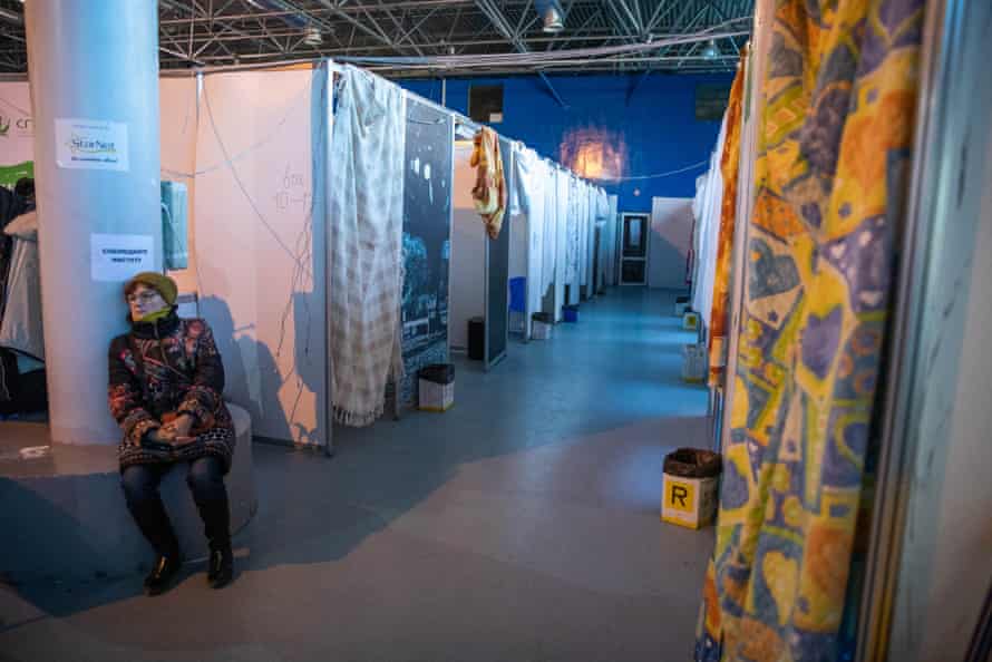 A woman sits inside an international exhibition centre in Chișinău that has been turned into temporary housing for Ukrainian refugees.
