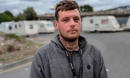 Lucas standing in front of a row of caravans in the background