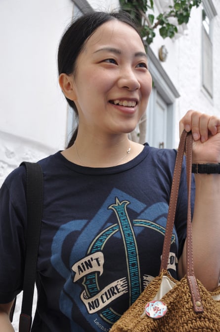 Wan Yan Qian, 30, from China, wearing a Cohen T-shirt (Ain’t No Cure for Love), a united hearts badge pinned to her basket, outside Cohen’s house on Hydra