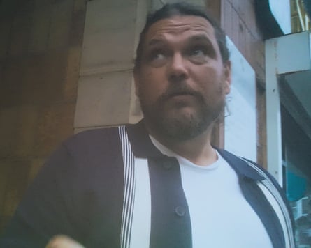 Undercover filming still of middle aged man with a beard.