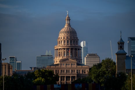 The Texas State Capitol dome rises above trees, with Austin's skyscrapers behind it at sunrise