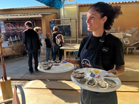 Smiling lady serving platters of oysters