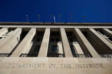 Columns of the Department of the Interior building rise against a clear blue sky